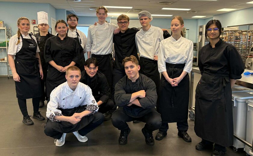 Elever i kokkeuniform på kjøkken - Klikk for stort bilde