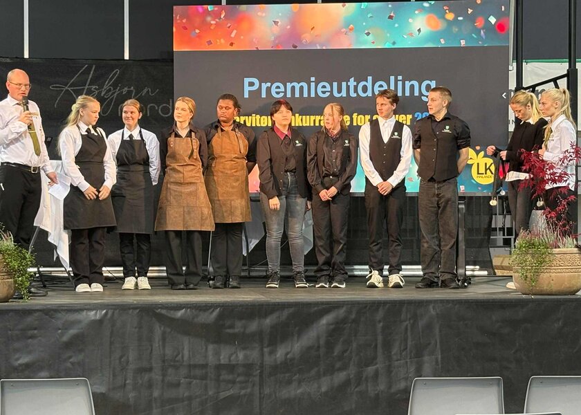 Åtte elever på rad på podium sammen med tred dommere - Klikk for stort bilde