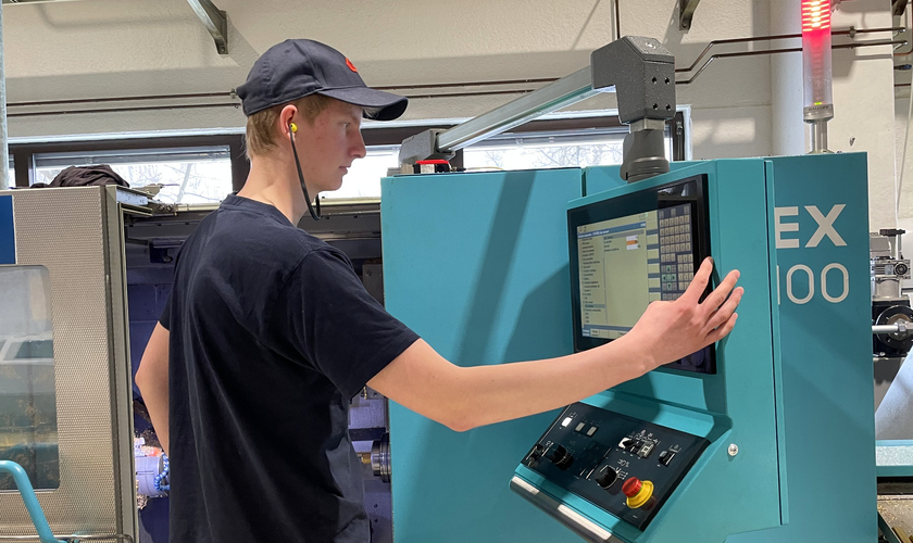 Gutt står ved CNC-maskin - Klikk for stort bilde